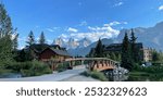 Wooden bridge over Spring Creek in Canmore, Alberta, with the Three Sisters peaks, in the Canadian Rockies in the background.