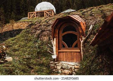 wooden brown door to a small house on a hill on a mountain in the woods like a hobbit. The Hobbiton