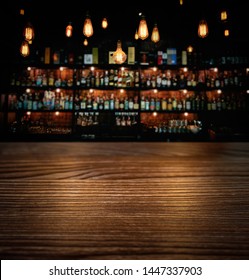 Wooden Brown Table And Vintage Lamps With Blurred Liquor Bar Background