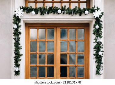 Wooden Brown Window Decorated With Christmas Branches Of Spruce With Cones And Toys. The Concept Of Festive Decor In The Exterior.
