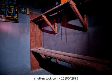 Wooden Bunk Beds In A Dark Basement Or Depressing Prison Cell And A Scheme Of The Room On The Wall