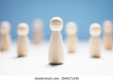 Wooden business team with one person standing out from the crowd concept for leadership or individuality - Shutterstock ID 2044171196