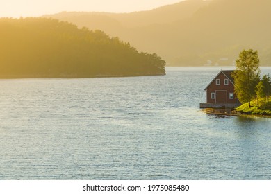 Wooden Cabin House On Water Fjord Shore. Summer Landscape In Norway, Scandinavia