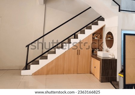 Wooden cabinet under the stairs, using the empty space under the stairs.  Negative space.  Contemporary Building Design with Modern Interior and Stylish Staircase