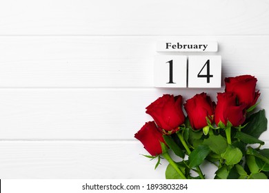 Wooden Calendar 14th February And Roses On White Background