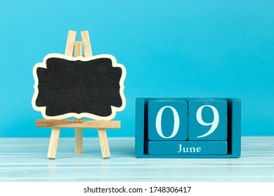 Wooden Calendar With The Date Of June 9 And An Easel On A Blue Background, Place For Text, Coral Triangle Day, International Accreditation Day, World Pet Memorial Day, International Archives Day