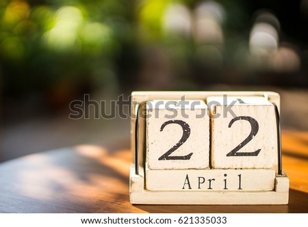 Wooden calendar on wooden desk show the date of April 22 , earth day with nature background