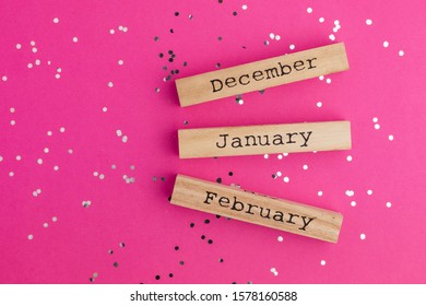 Wooden calendar winter months December January February. Pink background with multicolored confetti. Flat lay style. Top view - Powered by Shutterstock