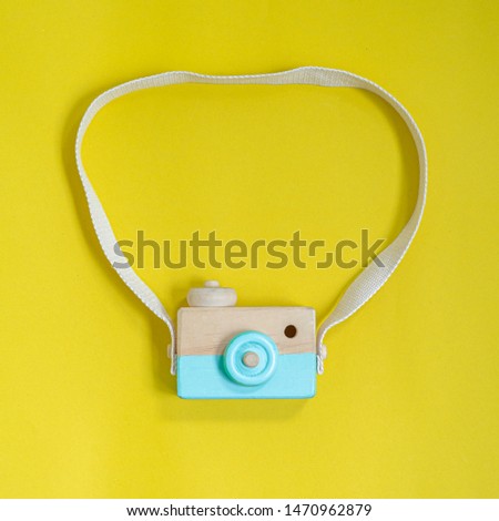 wooden camera toy wih yellow background