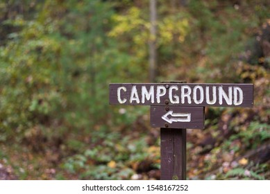 Wooden Campground Sign With Arrow In Autumn Forest