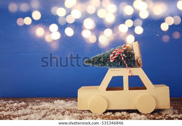 Wooden car\
carrying a christmas tree on the\
table