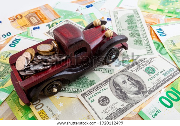 wooden car with coins on euro and dollars\
texture background