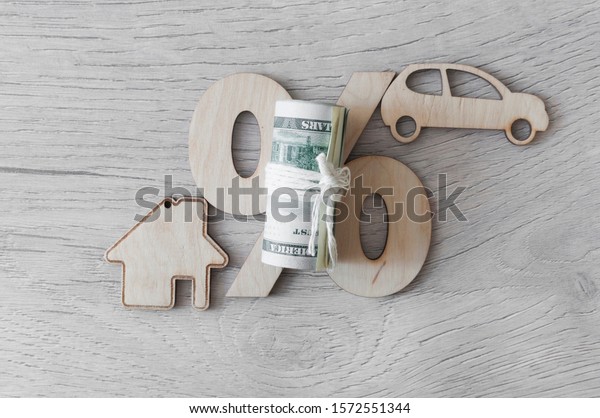 Wooden car and house\
model with percent sign. The concept of low interest rates on\
mortgage loans or rentals. The percentage of real estate sales. Tax\
interest. Loan secured. 