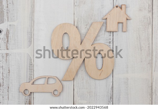 Wooden car and house\
model with percent sign. The concept of low interest rates on\
mortgage loans or rentals. The percentage of real estate sales. Tax\
interest. Loan secured. 
