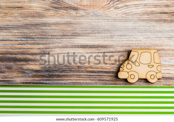 Wooden car on green stripes background. Eco\
energy concept
