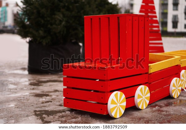 Wooden car on the playground. Winter,\
Christmas trees on a blurred\
background