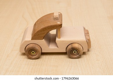 Wooden Car Toy. Miniature Retro Car Made Of Wood Pieces. Close Up Object Ton A Table.