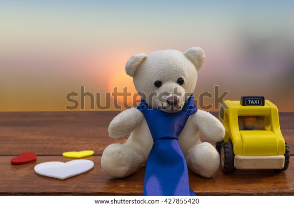 Wooden car with white teddy bear and
necktie on rustic wooden background, father's day
concept