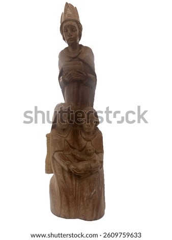 A wooden carving of the Holy Family (Mary, Joseph, and Jesus) with a standing figure above them, set against a white background.