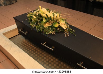 Wooden Casket With Funeral Flowers In A Crematorium Hall