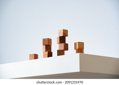 Wooden cedar cubes on white podium and background. Modern minimalism, climbing ladder and organic self-improvement, accepting a multi-faceted personality. Hero shot