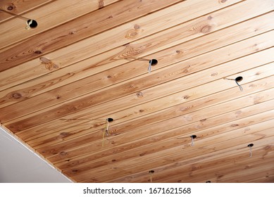 Wooden ceiling with holes for electric lamps
