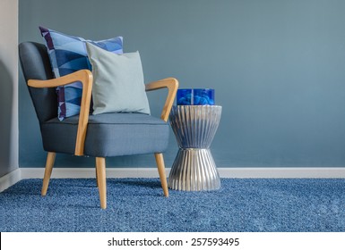 Wooden Chair With Blue Color Pillow On Carpet In Living Room