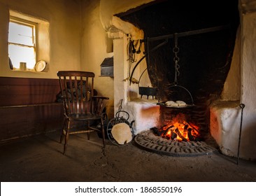 The Wooden Chair In The Old Style Antique Vintage Kitchen With Tools And Fireplace For Cooking