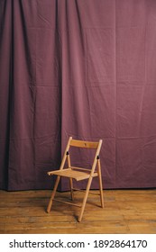 Wooden Chair On Burgundy Fabric Background