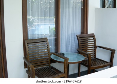 Wooden Chair And Round Glass Table In Front Of Home