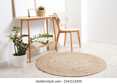 Wooden chair, table and wicker rug in light room - Shutterstock ID 2141112433