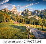 Wooden chalet on the shore of Gosausee lake. Picturesque summer view of green grassland  in Austrian Alps. Nice morning scene of Austrian countryside. Beauty of nature concept background.