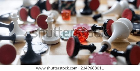 Wooden checkers, chess pieces, playing cards, board games on a light table close up.