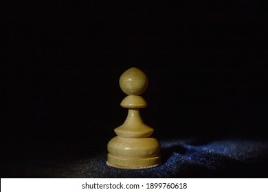 A Wooden Chess Pawn On Black Background