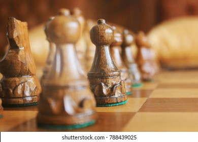 wooden chess pieces on a chessboard outdoor at the sunny day