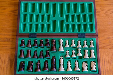 A Wooden Chess Set In Its Box, View From Above With Brown Background. The Picture Shows Old Traditional Hand-made Chess In A Box