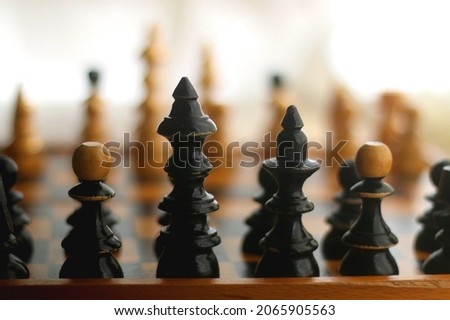Wooden chessboard and vintage carved figurines. Selective focus.