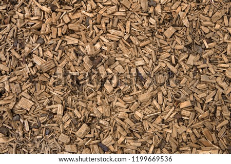 Wooden chips texture. Overhead shot. Brown chipped wooden pieces used as decoration. Kids Playground Mulch. Woodchips, wood, that has been chipped. Pieces of wood formed by cutting or chipping