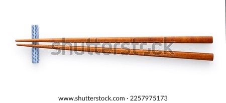 Wooden chopsticks and chopstick rests placed on a white background. Viewed from above.