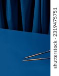 Wooden chopsticks set against a deep blue background with a blue curtain. Perfect for an Asian restaurant menu or a modern still life composition.