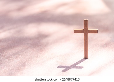 Wooden Christian cross on concrete floor. Christianity Concept. Faith hope love concept.
