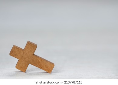 Wooden Christian cross on white table, space for text