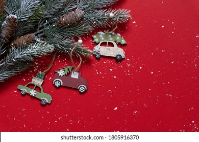 Wooden Christmas And New Year Toys On Christmas Tree Branches On The High Corner On Red Background With Snow, Top View, Copy Space, Banner, Holiday Mood.