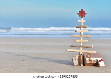 Wooden Christmas tree with gift boxes on the beach with copy space. Summer Christmas in the southern hemisphere  - Shutterstock ID 2390227855