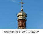 Wooden church with golden domes and place religion of orthodox christian. Built structure for prayer in modern city. Landscape with green park and tower with cross. Ukrainian orthodox church in dnipro