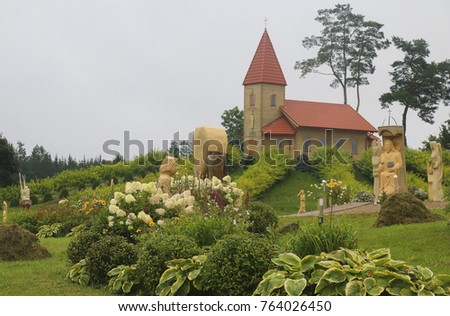 Wooden church on top of green decorated hill.