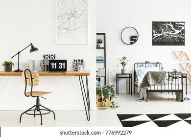 Wooden Classic Chair At Desk With Lamp And Laptop In Simple Boy's Bedroom With Round Clock Above Bed