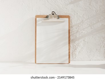 Wooden Clipboard With Blank A4 Paper With Copy Space On White Background With Floral Shadows. Minimal Concept.menu Board, Business Template.