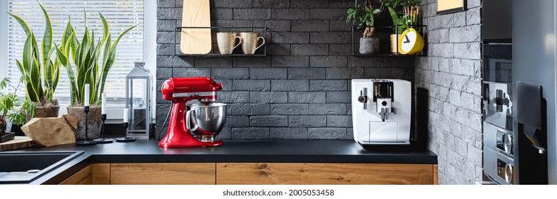 Wooden Clock On Black Brick Wall In Trendy Kitchen With Red Kitchen Robot