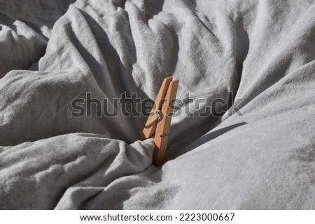 Wooden clothes peg on fabric background.